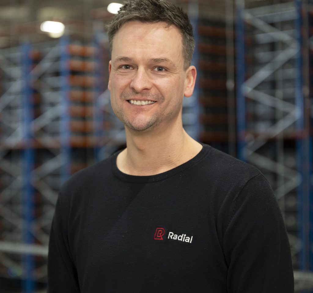 A man in a black shirt standing in a warehouse