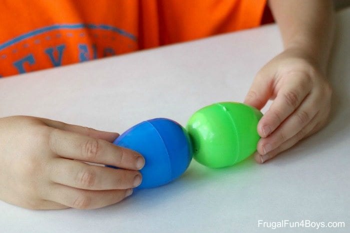 Child hold two plastic Easter eggs together, end to end