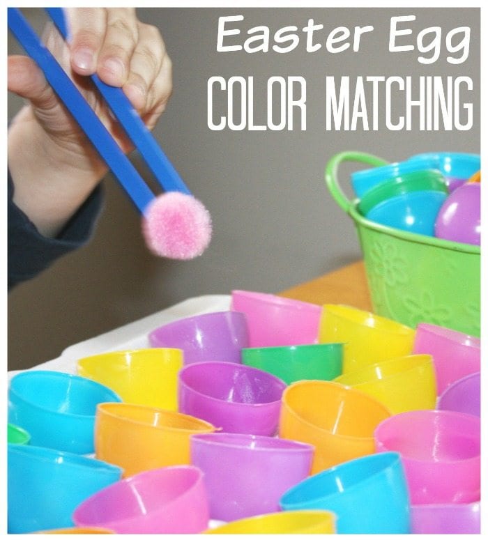 Child using plastic tweezers to sort colored pom poms into matching Easter egg halves