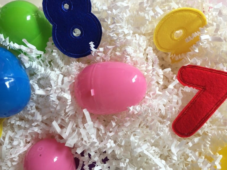 Sensory bin filled with plastic eggs and felt numbers