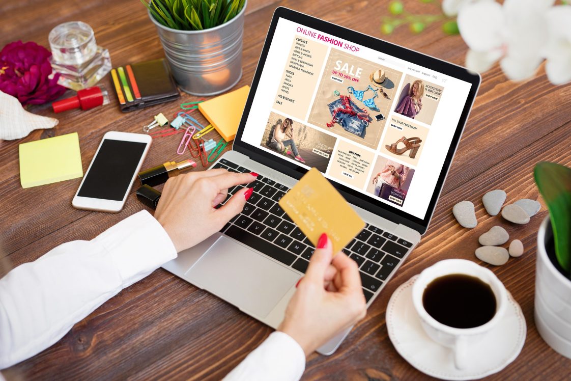 person shopping online with a credit card on a laptop