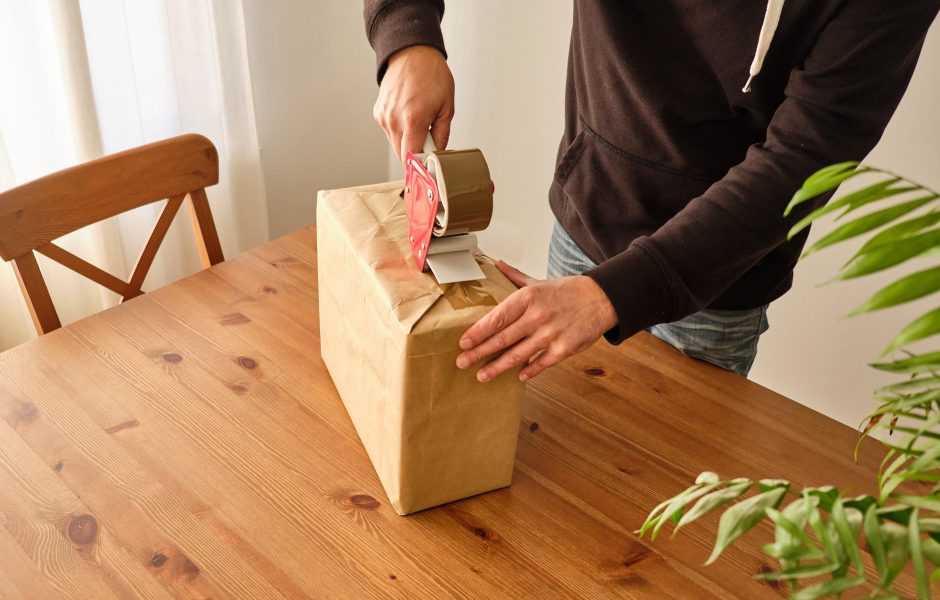 person taping up a package to be returned