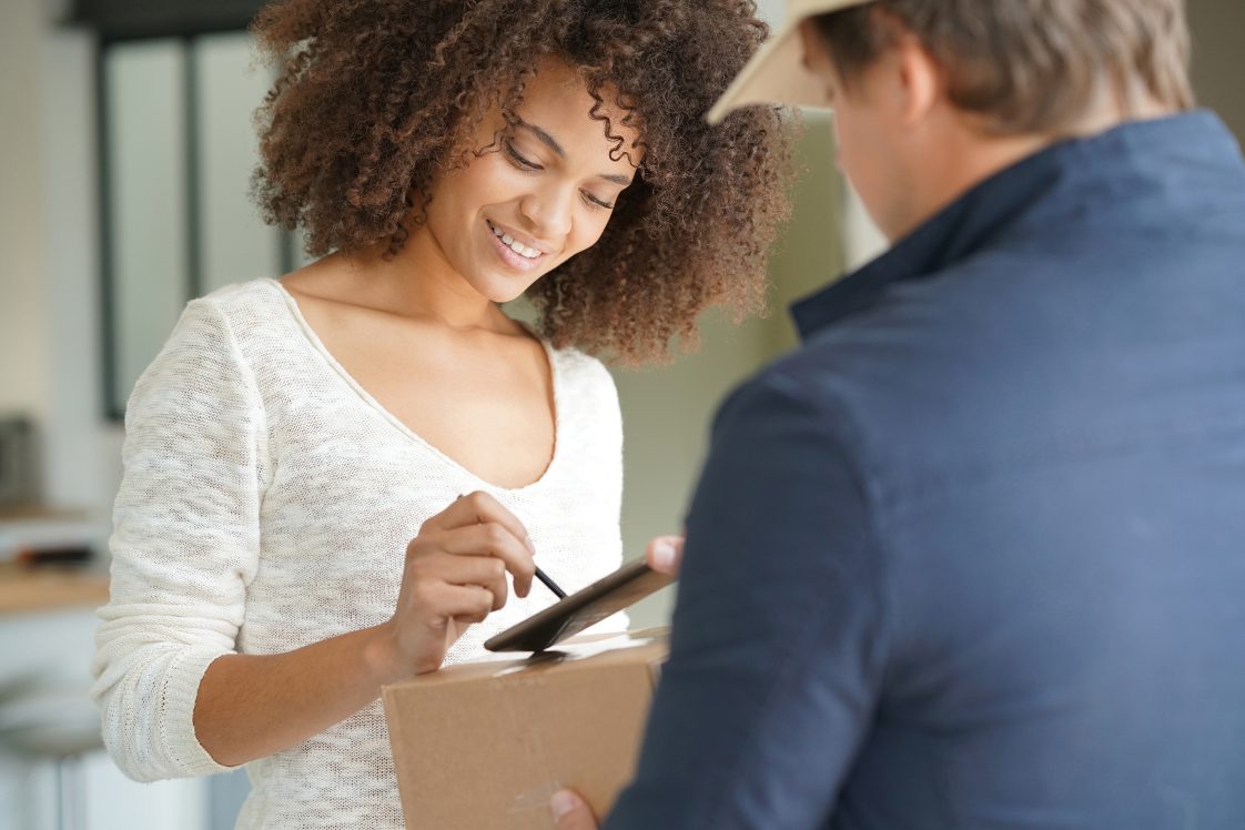 happy woman at door signing for a package