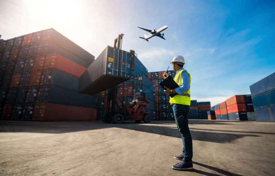 worker on walkie talkie in shipping container yard