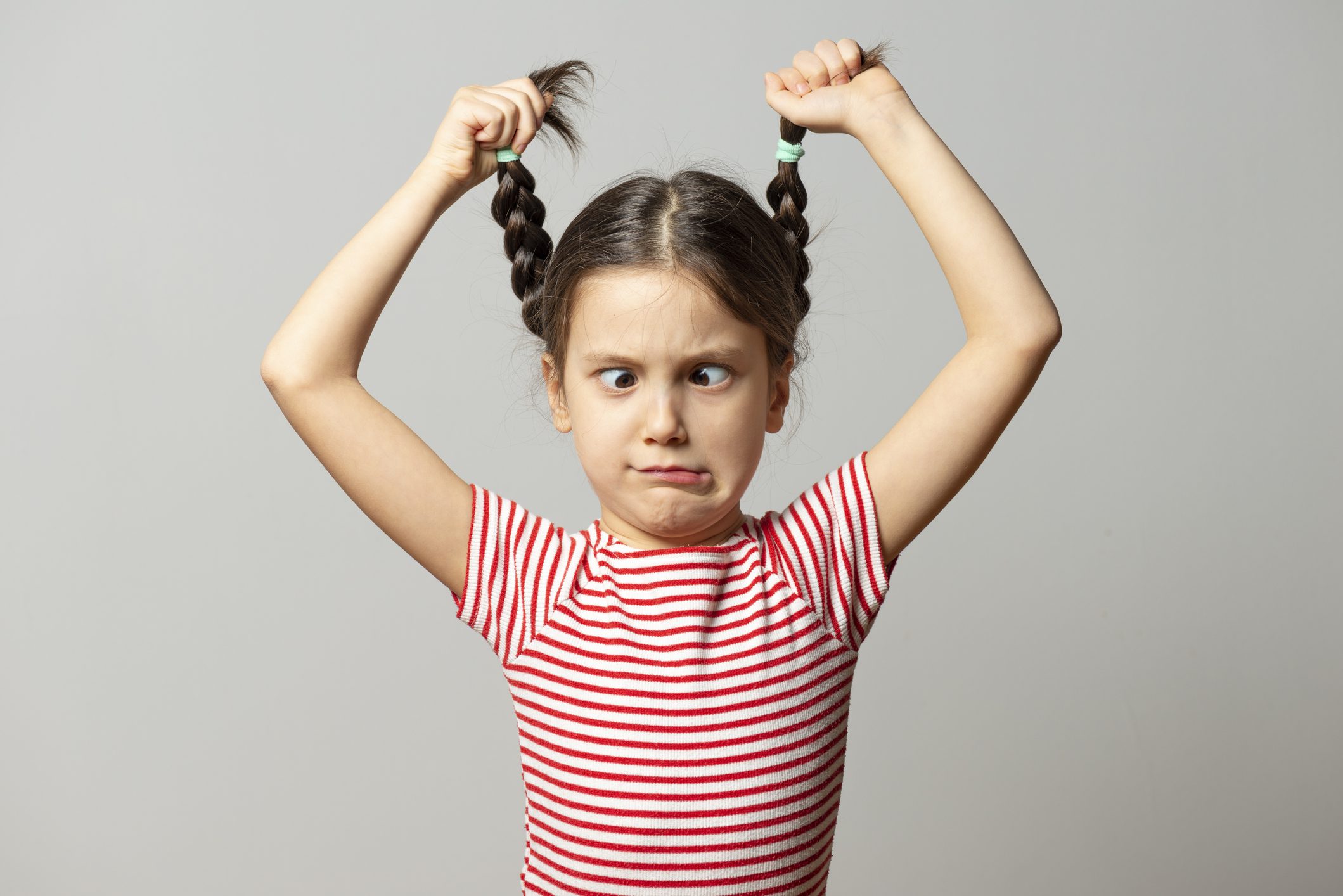 Girl holding pigtails in the air - we cant' blame the kids