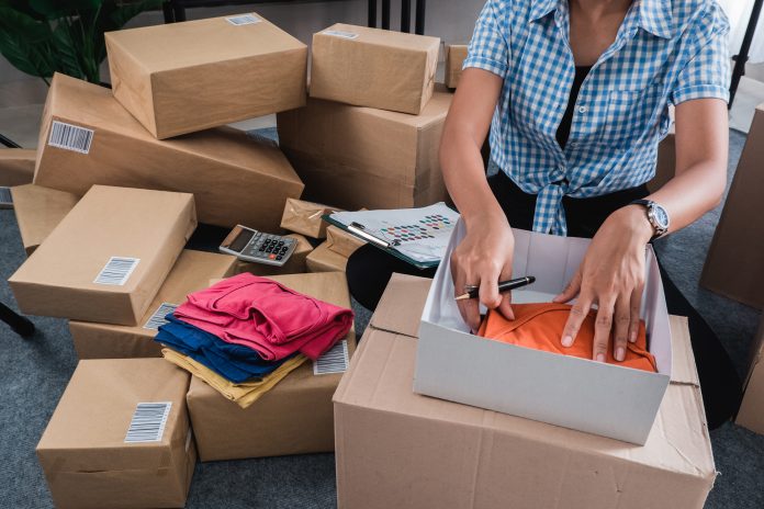 Woman sorting boxes in shipping area.